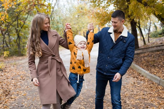 a family with a young son walk in the Park in autumn 1