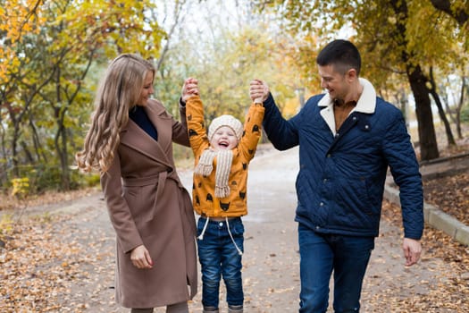 a family with a young son walk in the Park in autumn 1