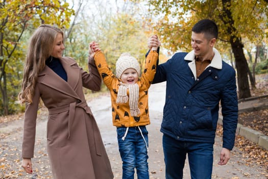 a family with a young son walk in the Park in autumn 1