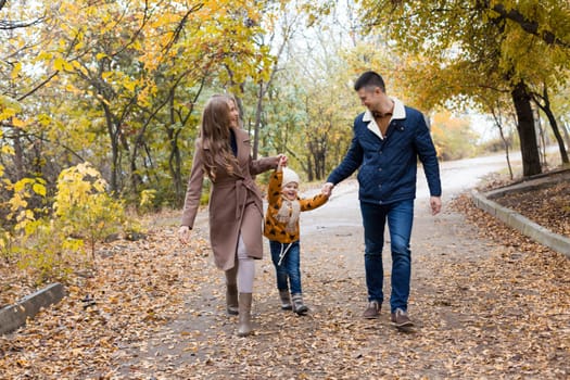 a family with a young son walk in the Park in autumn 1