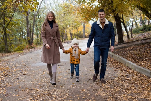 a family with a young son walk in the Park in autumn 1