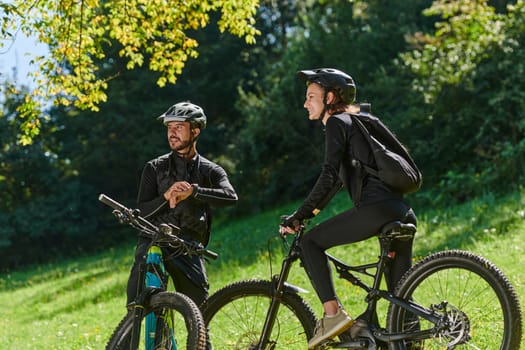 A sweet couple, equipped with bicycles and engrossed in coordinating their journey, checks their GPS mobile and watches while planning scenic routes in the park, seamlessly blending technology and outdoor adventure for a delightful cycling experience.