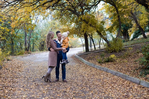 a family with a young son walk in the Park in autumn 1