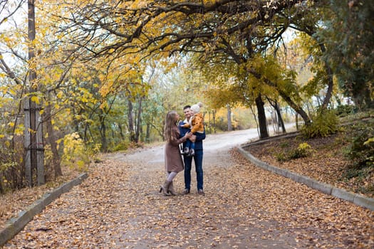 a family with a young son walk in the Park in autumn 1