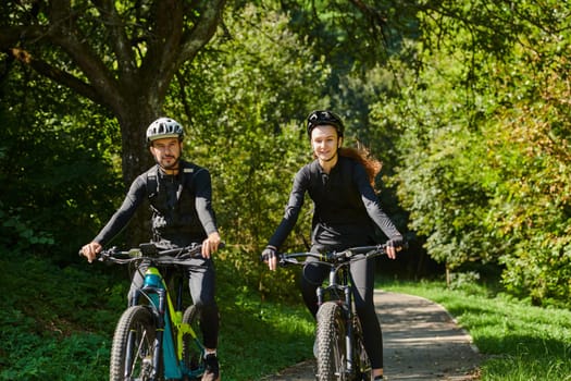 A blissful couple, adorned in professional cycling gear, enjoys a romantic bicycle ride through a park, surrounded by modern natural attractions, radiating love and happiness.