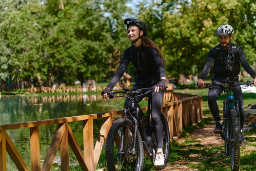 A blissful couple, adorned in professional cycling gear, enjoys a romantic bicycle ride through a park, surrounded by modern natural attractions, radiating love and happiness.