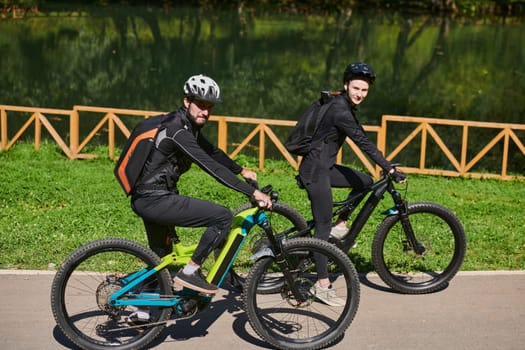 A blissful couple, adorned in professional cycling gear, enjoys a romantic bicycle ride through a park, surrounded by modern natural attractions, radiating love and happiness.