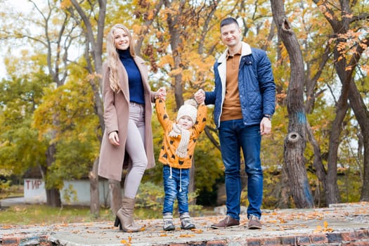 a family with a young boy in the autumn forest walk 1