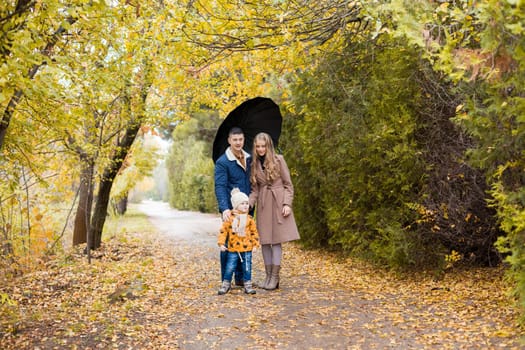 family walk in the autumn forest in the Park in the rain 1