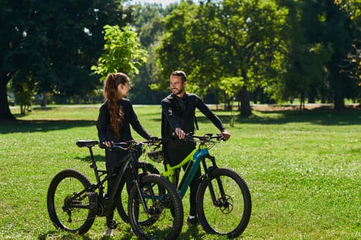 A blissful couple, adorned in professional cycling gear, enjoys a romantic bicycle ride through a park, surrounded by modern natural attractions, radiating love and happiness.