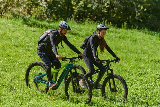 A blissful couple, adorned in professional cycling gear, enjoys a romantic bicycle ride through a park, surrounded by modern natural attractions, radiating love and happiness.