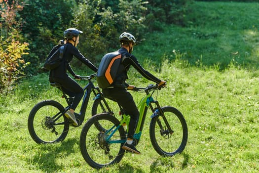 A blissful couple, adorned in professional cycling gear, enjoys a romantic bicycle ride through a park, surrounded by modern natural attractions, radiating love and happiness.