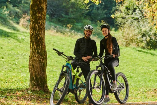 A blissful couple, adorned in professional cycling gear, enjoys a romantic bicycle ride through a park, surrounded by modern natural attractions, radiating love and happiness.