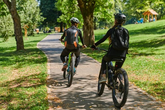 A blissful couple, adorned in professional cycling gear, enjoys a romantic bicycle ride through a park, surrounded by modern natural attractions, radiating love and happiness.