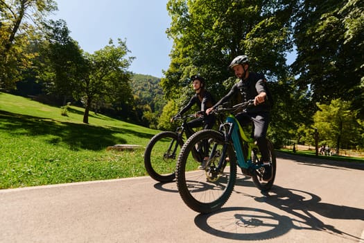 A blissful couple, adorned in professional cycling gear, enjoys a romantic bicycle ride through a park, surrounded by modern natural attractions, radiating love and happiness.