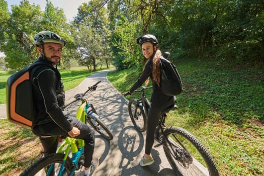 A sweet couple, adorned in cycling gear, rides their bicycles, their hands interlocked in a romantic embrace, capturing the essence of love, adventure, and joy on a sunlit path.