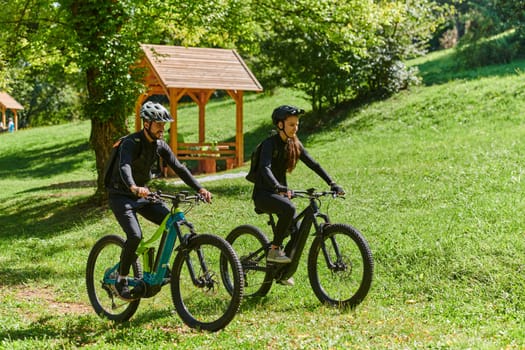 A blissful couple, adorned in professional cycling gear, enjoys a romantic bicycle ride through a park, surrounded by modern natural attractions, radiating love and happiness.