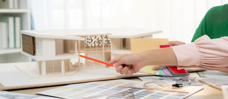 Professional architect team discussing about house design and appropriate interior materials. Cropped image of interior designers brainstorming about interior materials at meeting room. Variegated.