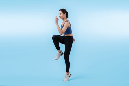 Side view young athletic asian woman on running posture in studio shot on isolated background. Pursuit of healthy fit body physique and cardio workout exercise lifestyle concept. Vigorous