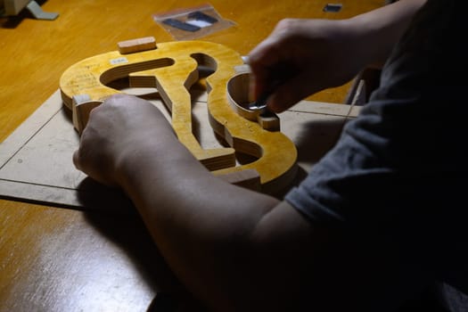 artisan violin maker luthier working on violin center bot, corner blocks , bend ribs for a new classic handmade violin using mold