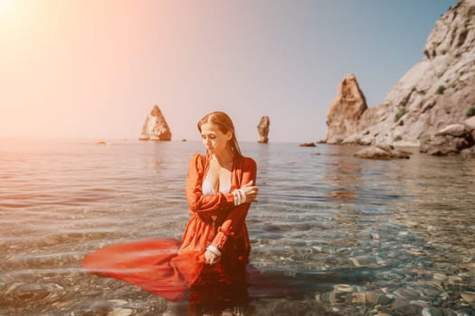 Woman travel sea. Happy tourist taking picture outdoors for memories. Woman traveler looks at the edge of the cliff on the sea bay of mountains, sharing travel adventure journey.