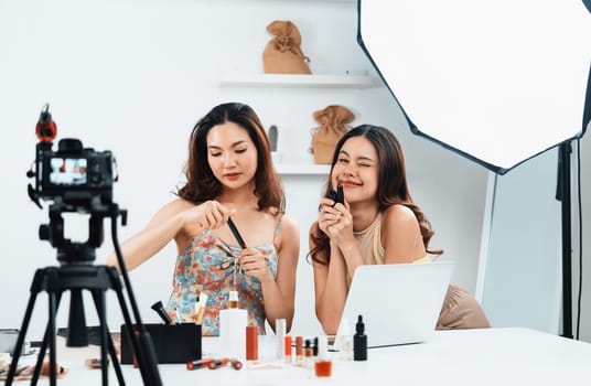 Woman influencer shoot live streaming vlog video review makeup uttermost social media or blog. Happy young girl with cosmetics studio lighting for marketing recording session broadcasting online.