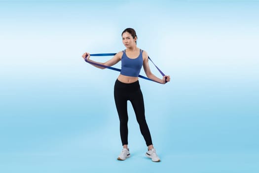 Vigorous energetic woman in sportswear portrait stretching resistance sport band. Young athletic asian woman strength and endurance training session workout routine concept on isolated background.