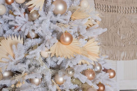 Close up of beautiful fir branches with shiny golden, silver and white baubles or balls, xmas ornaments and garland lights