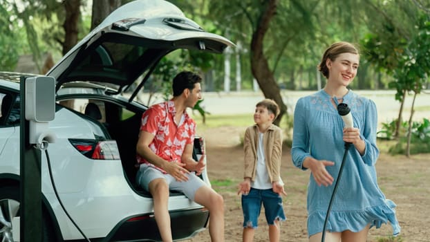 Family road trip vacation with electric vehicle, lovely family recharge EV car with green and clean energy. Natural and eco friendly car travel for sustainable environment. Perpetual