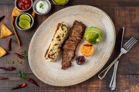 Mexican food carne a la tampiquena with sauces on wooden table