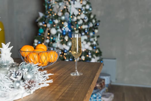 new year's still life, 2 glasses of champagne tangerines on the table on the background of the Christmas tree