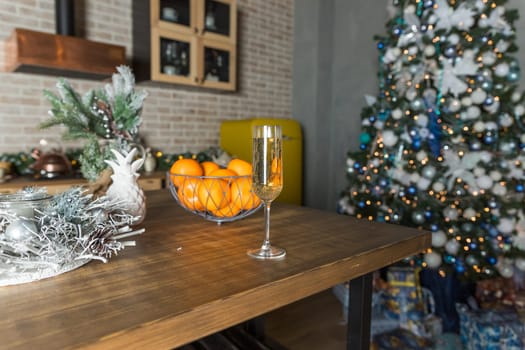 new year's still life, 2 glasses of champagne tangerines on the table on the background of the Christmas tree