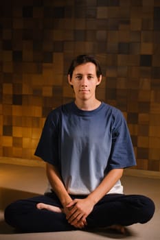 a man in a sports uniform does yoga in a fitness room. the concept of a healthy lifestyle.