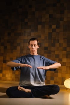 a man in a sports uniform does yoga in a fitness room. the concept of a healthy lifestyle.