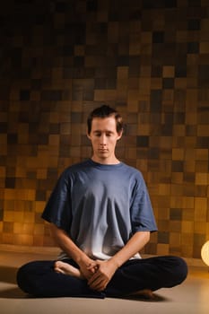 a man in a sports uniform does yoga in a fitness room. the concept of a healthy lifestyle.