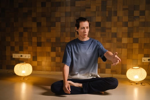 a man in a sports uniform does yoga in a fitness room. the concept of a healthy lifestyle.