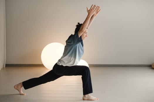 a man in a sports uniform does yoga in a fitness room. the concept of a healthy lifestyle.