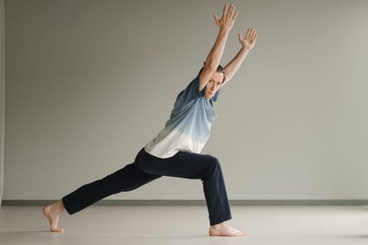 a man in a sports uniform does yoga in a fitness room. the concept of a healthy lifestyle.