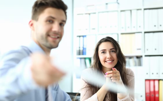 Portrait of successful entrepreneur in conference room holding paper document and smiling at camera. Business meeting and partnership concept