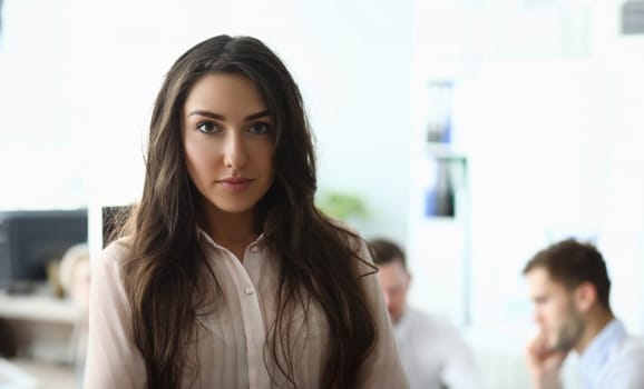 Portrait of young businesswoman in the background is employee working. Successful boss boss and career in business concept