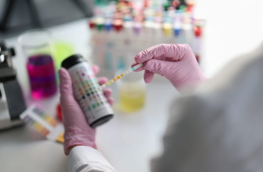 Chemist scientist holding ph test in hands closeup. Analysis in laboratory concept