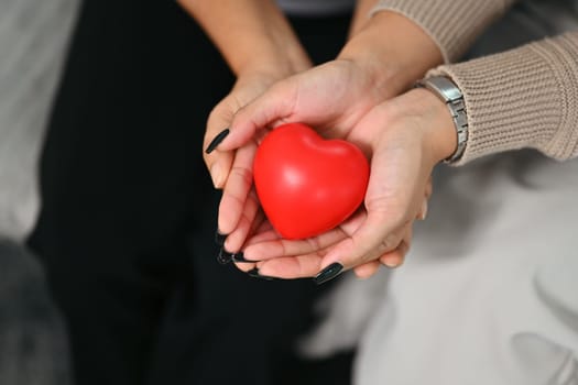 Women hands holding red heart. Health care, insurance and world heart day concept.
