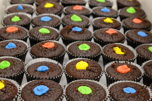 multi color muffins produce at professional catering baker in professional kitchen