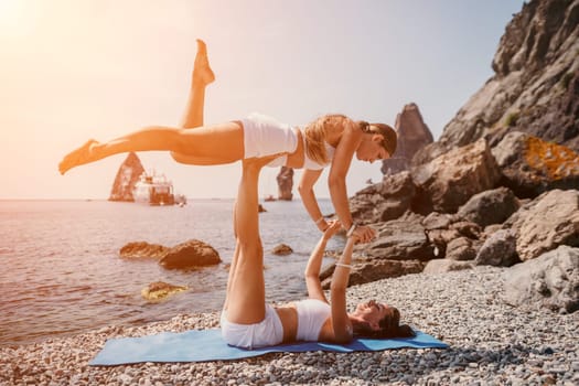 Woman sea yoga. Back view of free calm happy satisfied woman with long hair standing on top rock with yoga position against of sky by the sea. Healthy lifestyle outdoors in nature, fitness concept.