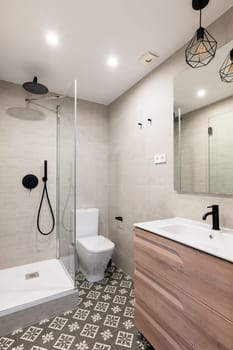 Shower cabin toilet bowl and wash basin in renovated bathroom. Contemporary equipment and furniture for hygiene in hotel room interior design