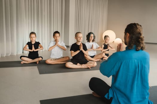 Children do yoga in the gym under the guidance of an instructor. Children's gymnastics.