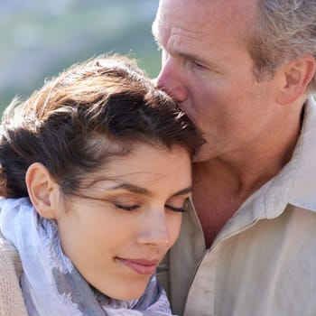 Couple, forehead kiss and love with respect or happiness on holiday in retirement. Mature, man and woman embrace together outdoor on vacation in nature or show affection or gratitude in marriage.