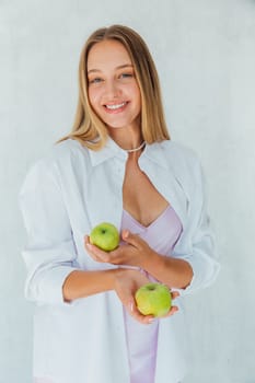 Beautiful woman nutritionist holding green apples in her hands
