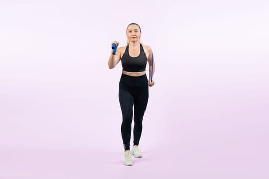 Full body length shot athletic and sporty senior woman with fitness exercising rope on isolated background. Healthy active physique and body care lifestyle senior people. Clout