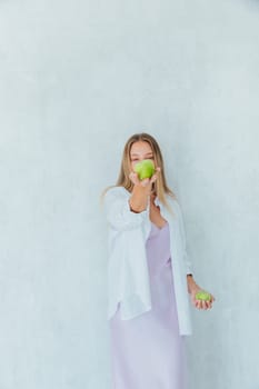 Beautiful woman nutritionist holding green apples in her hands